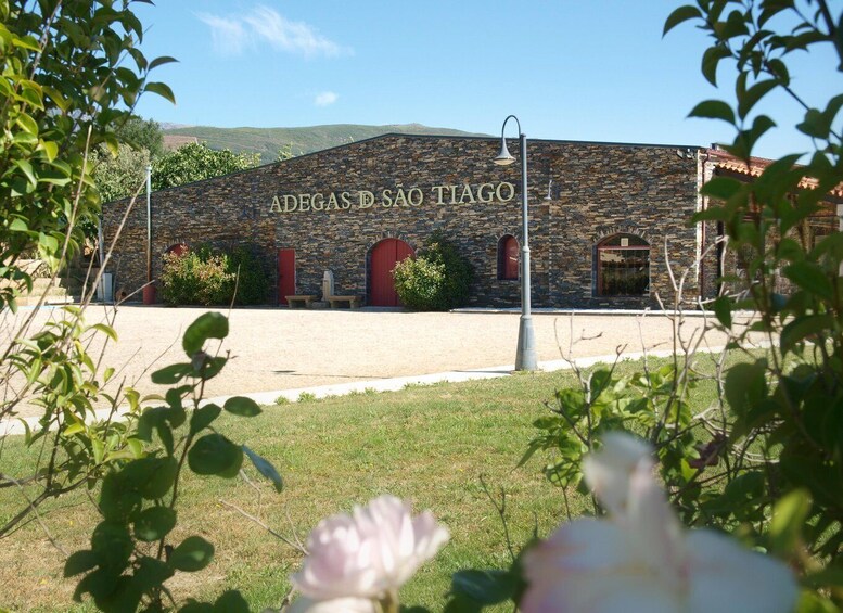 A building with a stone facade and the inscription 'ADEGAS D SÃO TIAGO'. 4