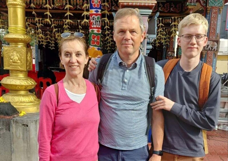 Three people standing in front of a colorful, ornate structure with intricate designs. 4