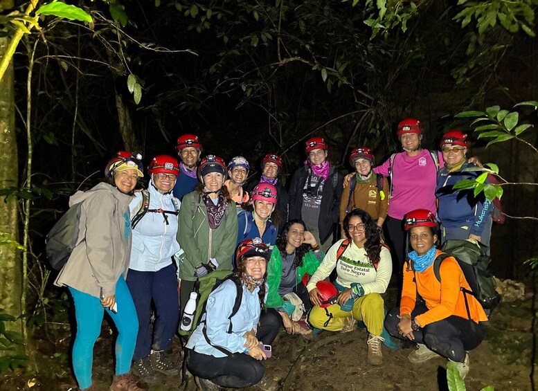 A group of people wearing helmets and backpacks in a forested area. 4