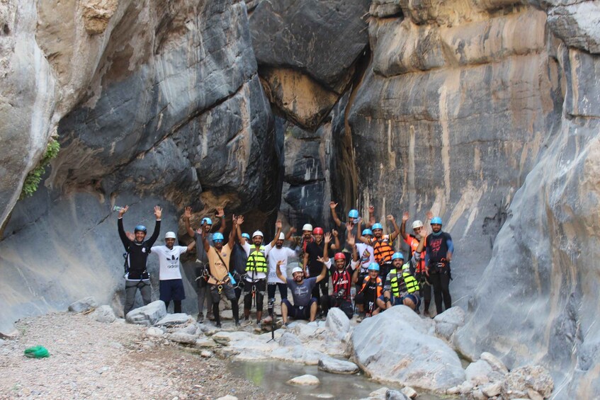A group of people in a rocky canyon with a narrow passage. 1