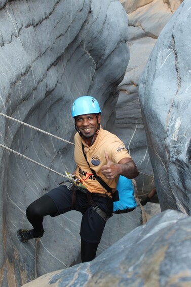 A person rappelling down a rocky cliff. 4