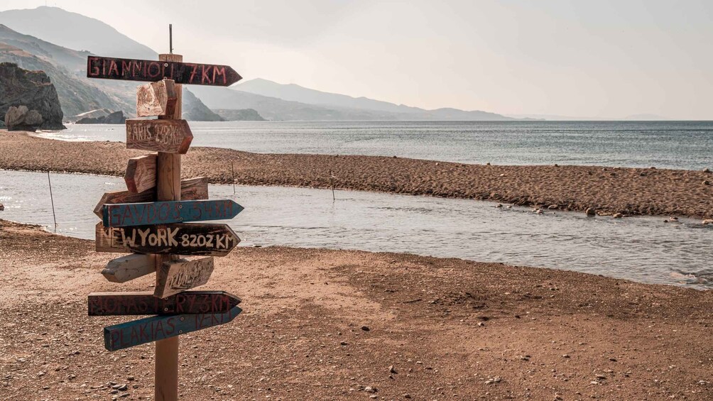 A wooden signpost with multiple directional signs pointing to various destinations and distances. 4