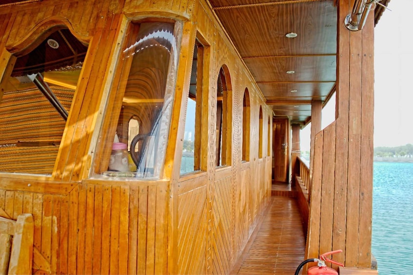 A wooden boat deck with arched windows and a clear view of the water. 3