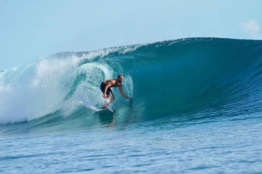 A surfer riding a large wave in the ocean. 3
