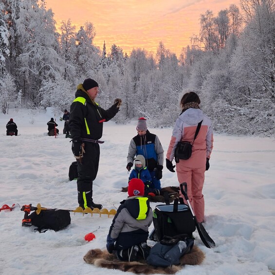 A group of people in a snowy forest with a sunset in the background. 3