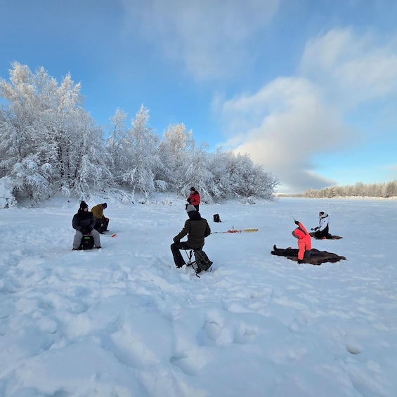 A snowy landscape with people engaged in ice fishing. 5