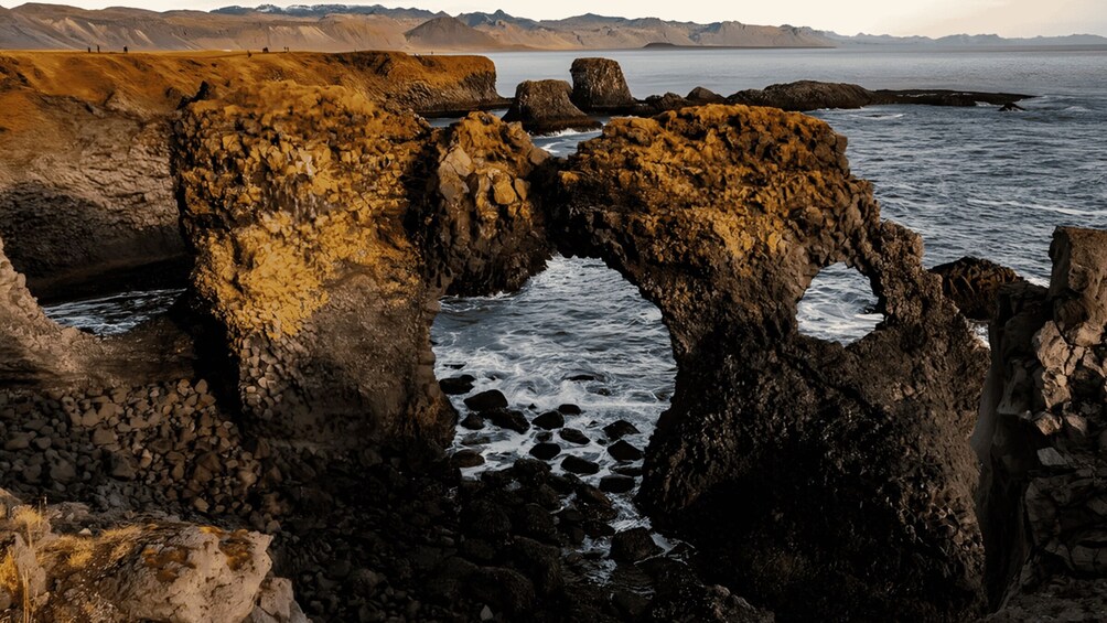 A coastal landscape with prominent rock formations and a calm sea. 3