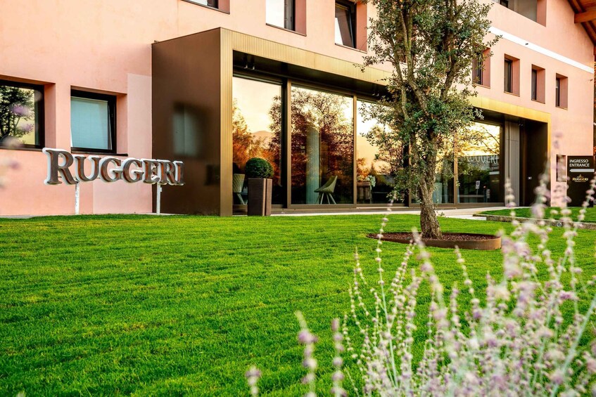 A building with a sign reading 'RUGGERI' and a well-maintained lawn in front. 1