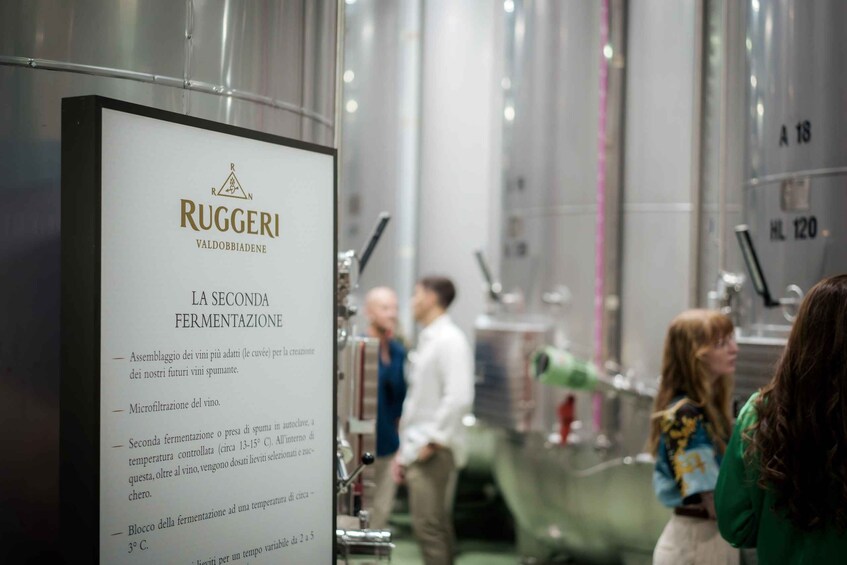 A wine tasting event with a sign for Ruggeri Valdobbiadene, detailing the second fermentation process. 2
