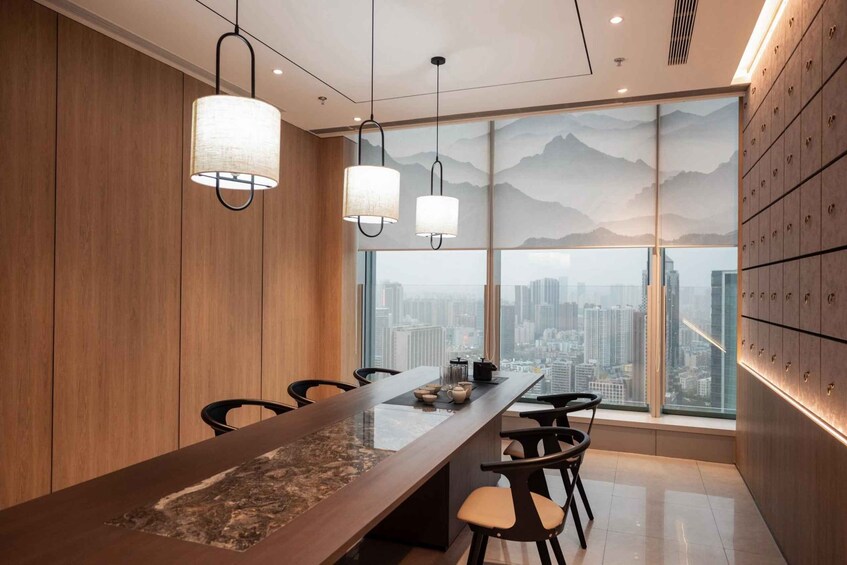 A modern conference room with a long table, chairs, and a cityscape view through large windows. 5