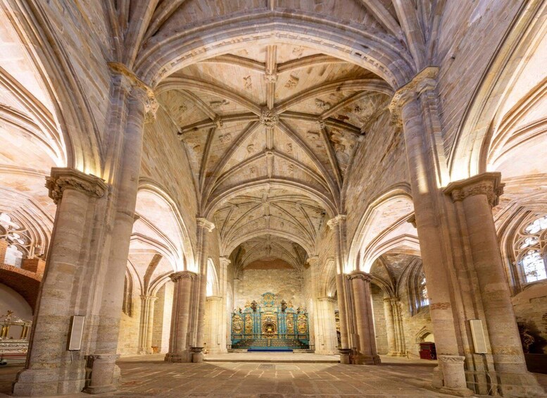 A cathedral interior with high vaulted ceilings, large stone columns, and a central altar. 3