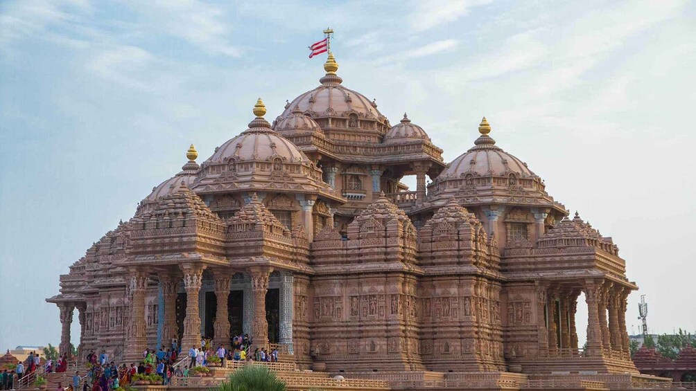 A large, intricately carved temple with multiple domes and spires, featuring a flag on top. 1