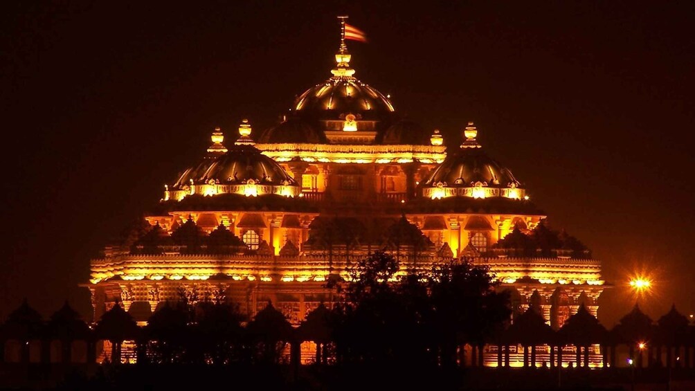 A brightly lit temple with multiple domes and intricate architecture at night. 5