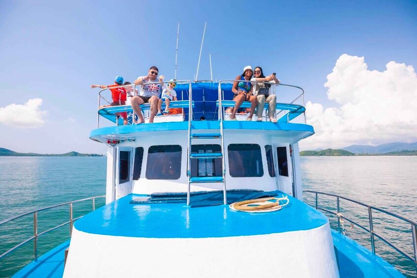 A boat with people on the deck, a clear sky, and calm water. 2