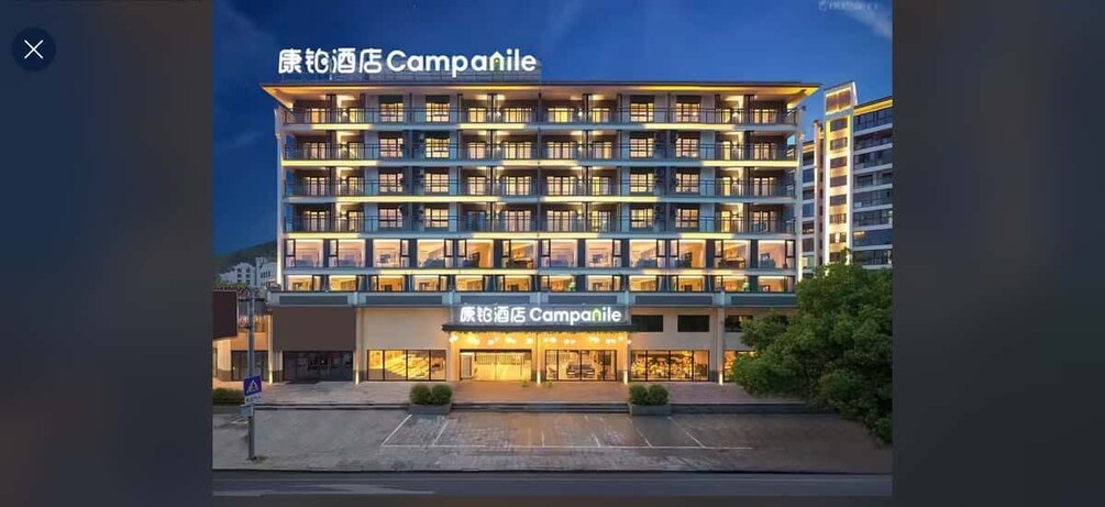 A multi-story hotel building with illuminated signage and a well-lit entrance. 5