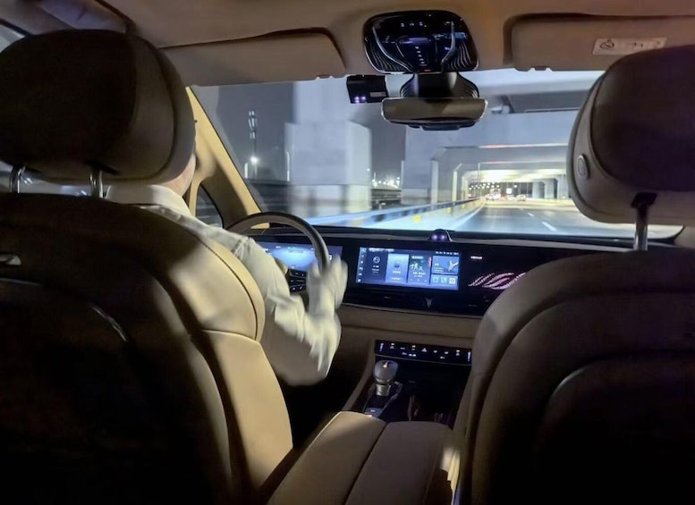 A car interior with a digital dashboard, leather seats, and a sunroof. 2