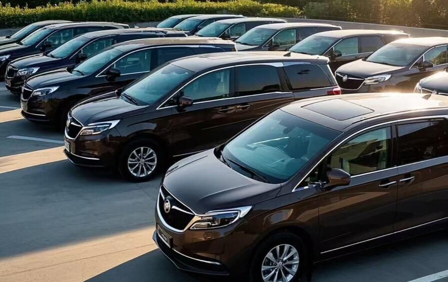 A row of black sedans parked in a lot. 4