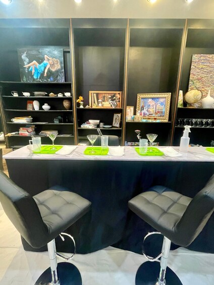 A conference table with green placemats, black chairs, and a black tablecloth. 1