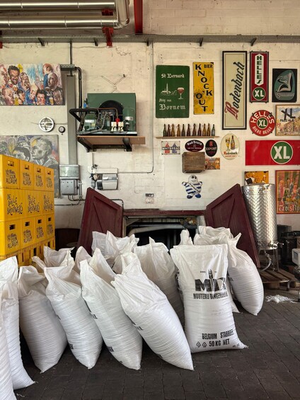 A brewery with various beer labels, sacks of malt, and brewing equipment. 5