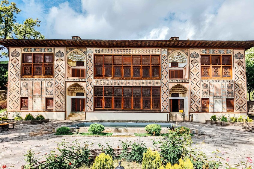 A traditional building with intricate tile work and wooden windows. 1