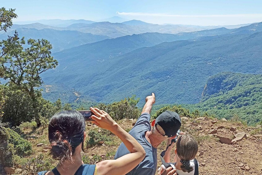 A group of people on a mountain ridge, taking a photo of the landscape. 2