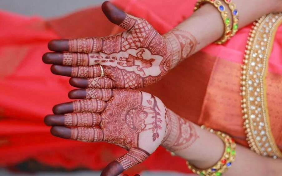 A person with intricate henna designs on their hands and wrists. 2