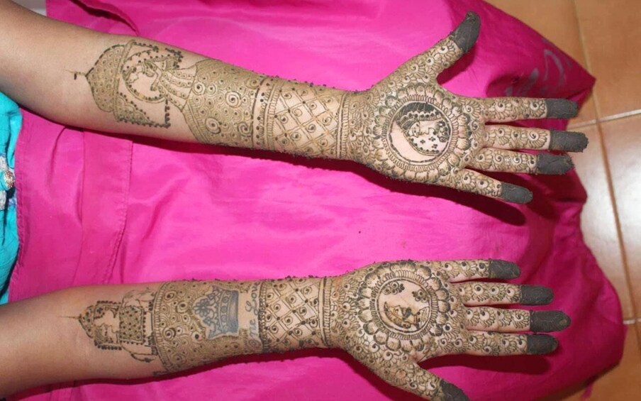 A person with intricate henna designs on their hands and forearms. 4