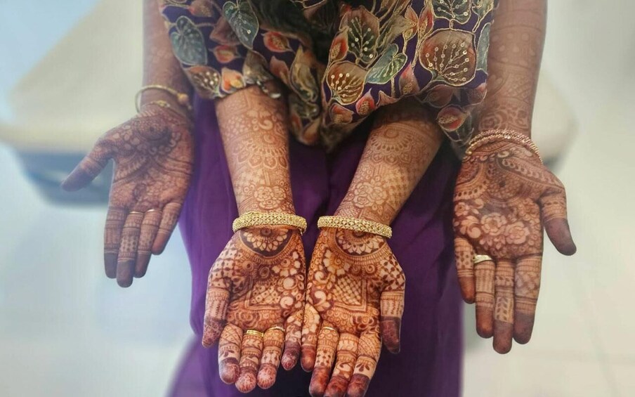 A person with intricate henna designs on their hands and wrists. 5