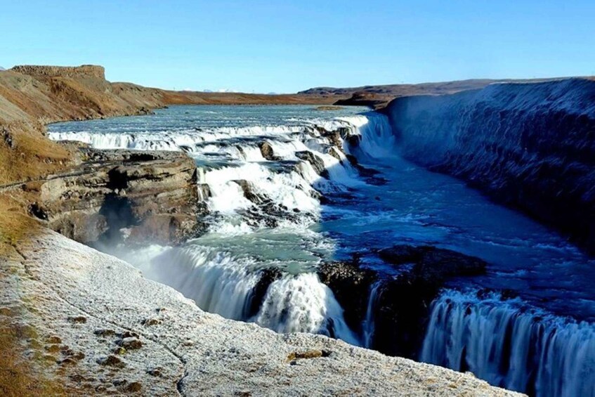 A large waterfall cascading over a rocky cliff into a river. 3