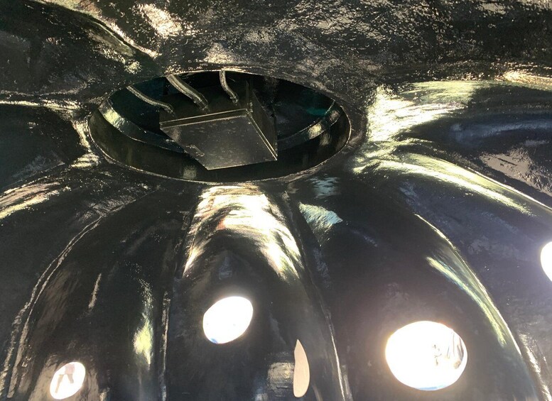 A shiny metallic surface with circular indentations and a central rectangular cutout. 4