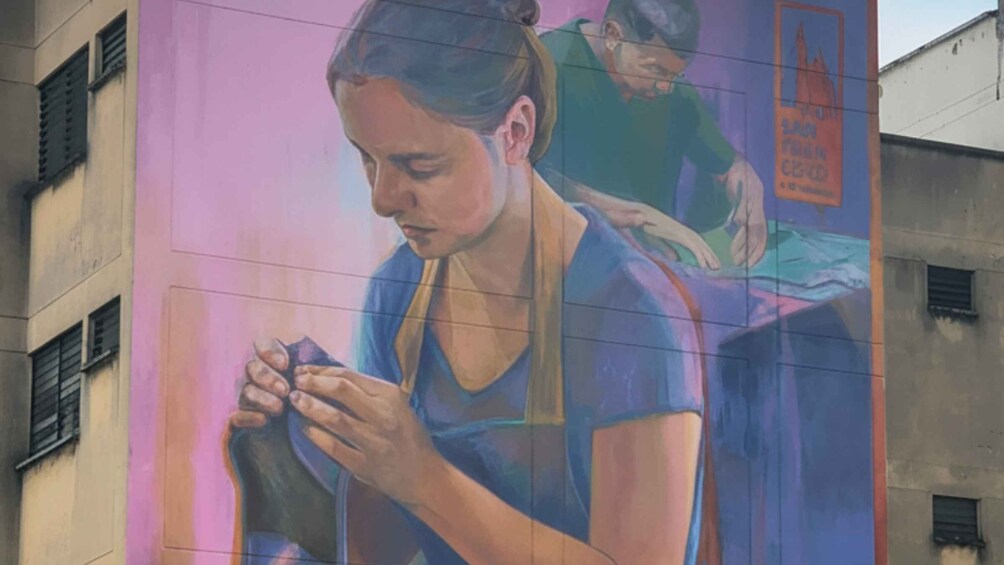 A mural of a woman sewing on a table. 1