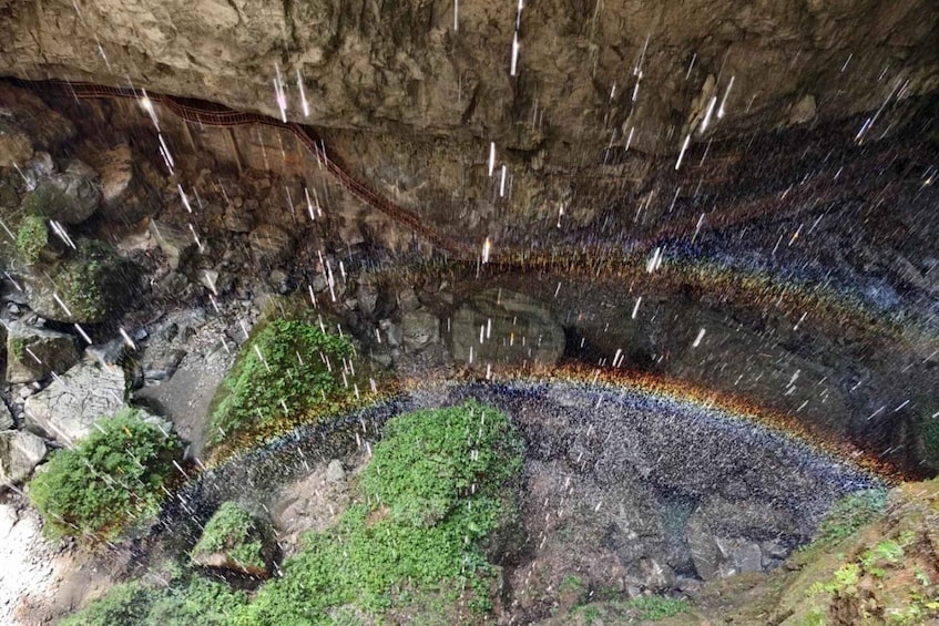 A rock formation with a staircase descending into a cave. 3