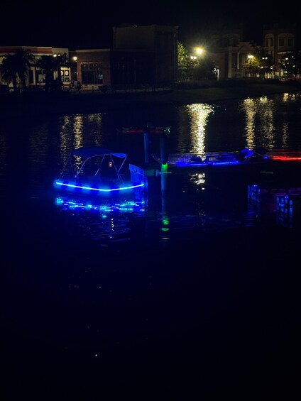 A boat with blue lights docked at a pier. 2