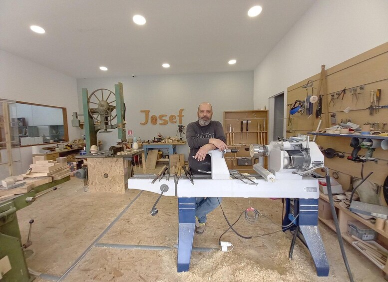 A woodworking shop with a man standing by a table saw. 5