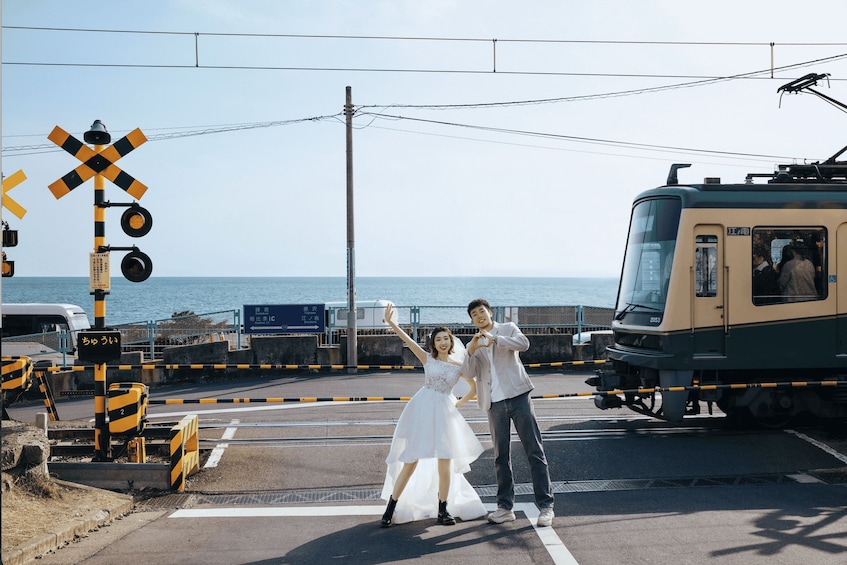 A wedding scene with a couple posing in front of a train. 1
