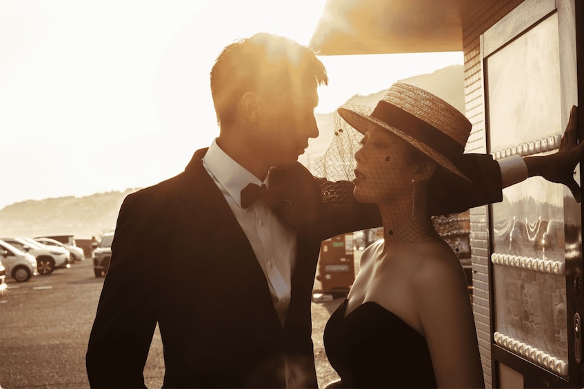 A couple embracing in a parking lot with a building in the background. 4
