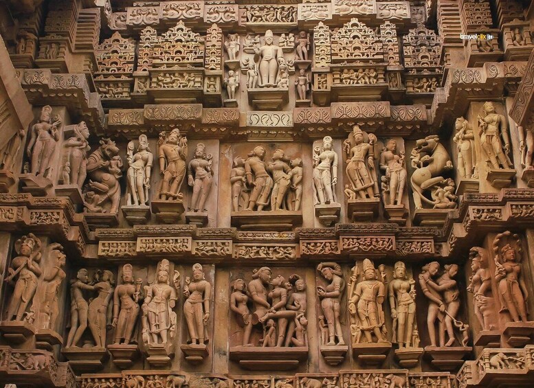 A detailed stone carving with multiple figures, intricate patterns, and a central deity. 1