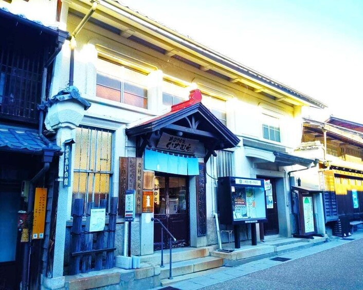 A traditional Japanese building with a sloped roof and a signboard. 2