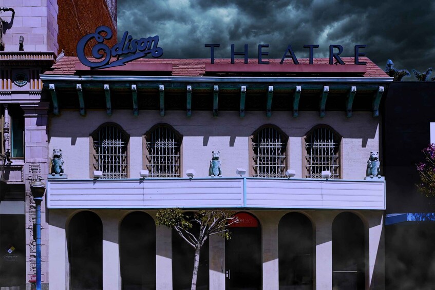 A theater with a sign reading 'Cadillac Theatre' and a tree in front. 3