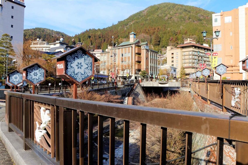 A bridge with decorative metal railings, a river below, and buildings in the background. 5