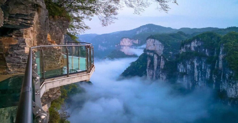 A glass bridge over a river with cliffs. 4