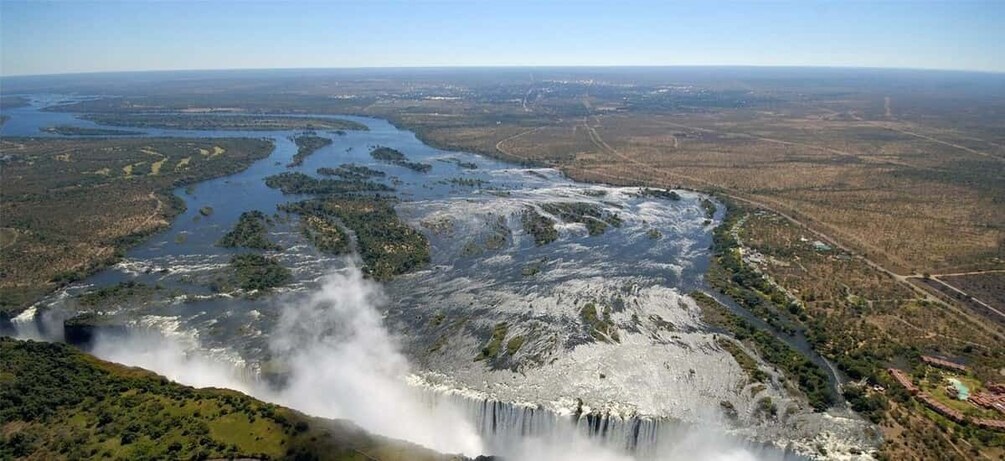 A waterfall cascading into a river surrounded by forested landscape. 3