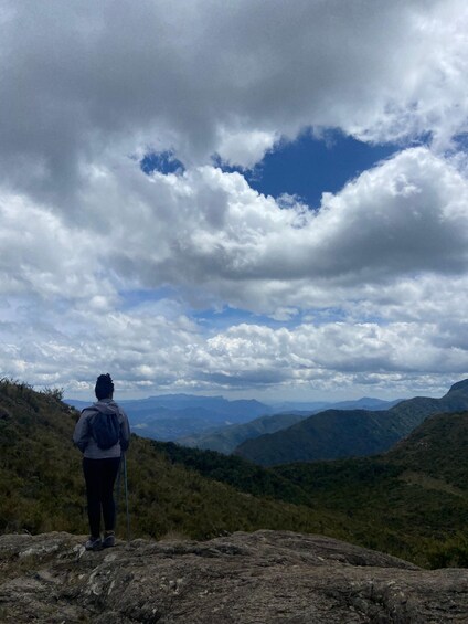 A person hiking on a rocky terrain with a mountainous landscape in the background. 3