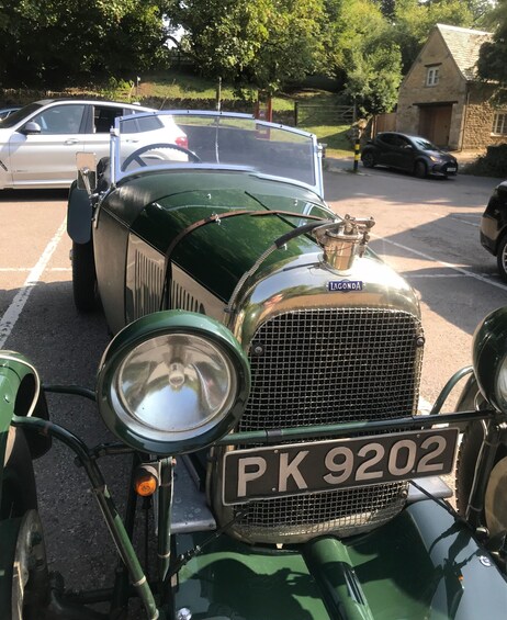 A vintage green car with a license plate PK 9202 parked in a parking lot. 2