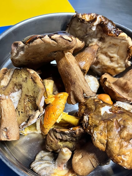 A variety of mushrooms in a metal bowl. 2