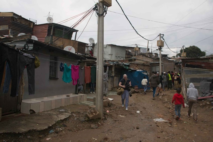 A densely populated urban area with makeshift housing, utility poles, and satellite dishes. 5