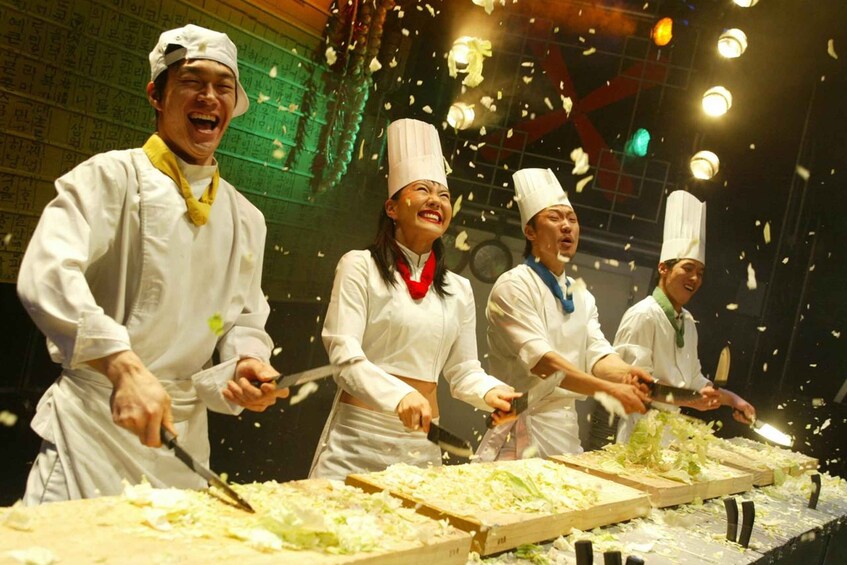 Chefs in white uniforms and hats, preparing food with vegetables on wooden boards. 5