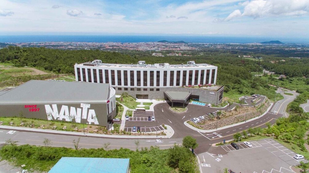 A large building complex with a parking area and roads. 3