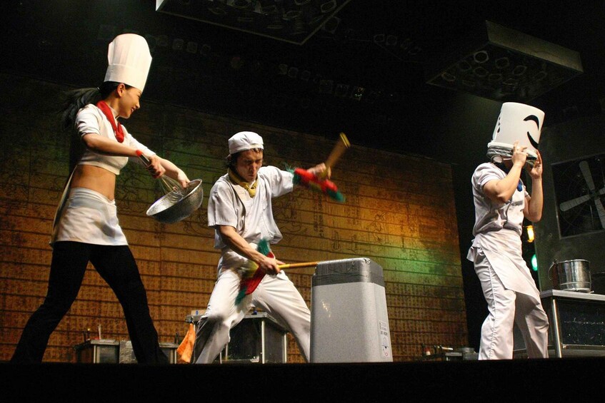 Chefs performing synchronized cooking actions on stage. 2