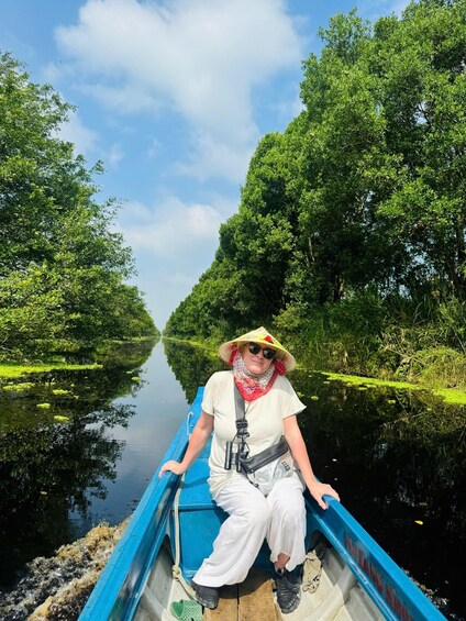 A person in a boat on a calm river surrounded by lush greenery. 2